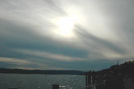 26.06.04: 18 Uhr 57-36: Ab ca. 17 Uhr geschlossene Wolkendecke fast ber dem gesamten Bodensee. Aufnahme an berlinger Promenade. Um die Sonne sind noch Flugspuren zu sehen. Wolken wurden an diesem an sich klaren Hochdrucktag ausschlielich von Flugzeugen gebildet!!